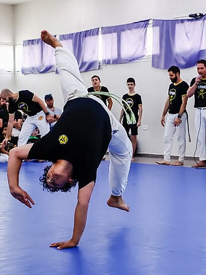 נער מקבוצת הנוער של קפואירה קדימה מבצע תרגיל אקרובטי בשיעור קפואירה לנוער